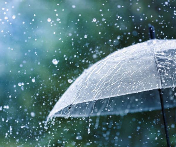Transparent umbrella under heavy rain against water drops splash background. Rainy weather concept.